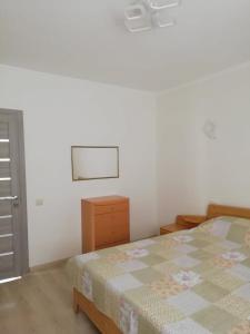 a white bedroom with a bed and a dresser at Трускавець Апартаменти. in Truskavets