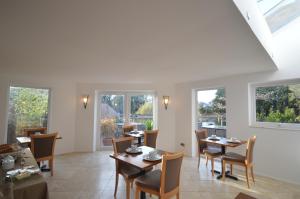 a dining room with tables and chairs and windows at Lakeside Old Hunstanton in Hunstanton