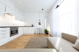 a white living room with a couch and a kitchen at The Hammock Lodge, Holborn, by the Design Traveller in London