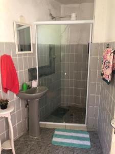 ein Badezimmer mit Dusche und Waschbecken in der Unterkunft APARTAMENTO FRENTE A PRAIA SAO VICENTE in São Vicente + 5 Fotos