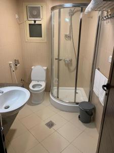 een badkamer met een douche, een toilet en een wastafel bij Manazelna Aparthotel in Jeddah