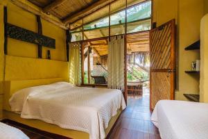a bedroom with two beds and a large window at Kimbas Bungalows Mancora in Máncora