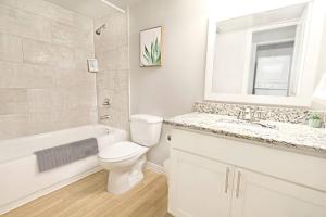 a white bathroom with a toilet and a tub and a sink at Global Cup The Alcove Dallas Near Downtown Fun Nightlife in Dallas +17 photos