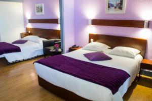 a hotel room with two beds with purple walls at Hotel Estoril Porto in Porto