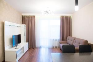 sala de estar con sofá y TV en Apartments u Kremlya, en Kazán