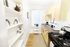 una cucina con mobili bianchi e un forno a piano cottura di The Explorer's Hearth Lower-Greenville Ave Area a Dallas