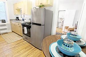 una cucina con frigorifero in acciaio inox e piatti sui tavoli di The Explorer's Hearth Lower-Greenville Ave Area a Dallas Altre 18 foto