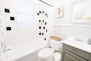 un bagno bianco con un water e un lavandino di The Explorer's Hearth Lower-Greenville Ave Area a Dallas