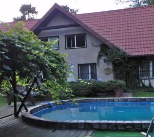 ein Haus mit einem Pool vor einem Haus in der Unterkunft DOM 4 POKOJE Z BASENEM BLISKO WARSZAWY in Józefów
