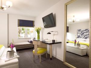 a hotel room with a desk and a bed and a mirror at Hotel Breakwater South Beach in Miami Beach