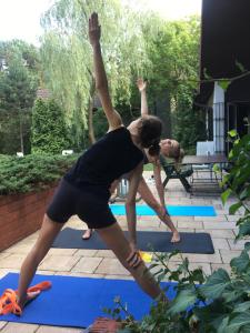 Eine Frau, die eine Yoga-Pose im Garten macht. in der Unterkunft DOM 4 POKOJE Z BASENEM BLISKO WARSZAWY in Józefów