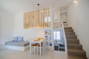 a room with a bed and a table and a staircase at Island House Mare in Mylopotas +31 photos