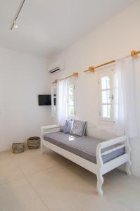 a bed in a white room with a window at Island House Mare in Mylopotas