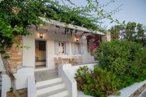 a home with white walls and stairs and plants at Island House Mare in Mylopotas