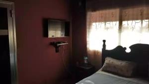 a red bedroom with a bed and a window at HAKABA in Conakry