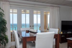White Sands Beach Condos في كرايست تشيرش: غرفة طعام مع طاولة وكراسي والمحيط