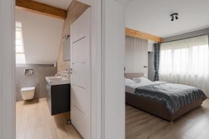 a bedroom with a bed and a bathroom with a sink at Discovery Aparthotel in Cluj-Napoca