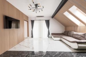 Una sala de estar con un sofá y un televisor. en Discovery Aparthotel, en Cluj-Napoca
