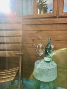 butelka wina na stole z dwoma kieliszkami w obiekcie Ferienhaus Kleine Pfalz w mieście Ranschbach