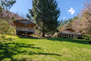 ウェインズビルにあるSmoky Mountain Escape with Large Deck and Game Room!の木のある草原にある2軒の家