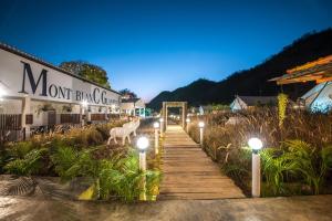 a wooden walkway with lights in front of a building at Mont Blanc Glamping Khao Yai in Mu Si