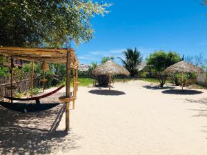穆龍達瓦的住宿－Villa A.TIA，海滩上的吊床和草伞