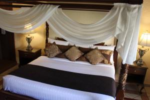 a bedroom with a large bed with a canopy at Hotel Posada Virreyes in Guadalajara