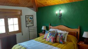 a bedroom with a bed with a green wall at Casa Rural Los Jamones in Arroyo Frio