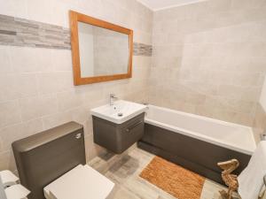 a bathroom with a toilet and a sink and a bath tub at Bay View in Holyhead +24 photos