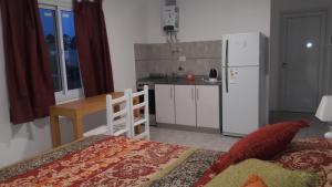 a kitchen with a bed and a kitchen with a refrigerator at Aluminé in Colón +27 photos