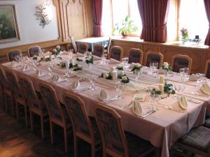 a long table with glasses and flowers on it at Tamina Hotel in Vättis
