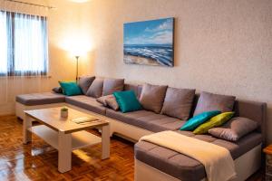 ein Wohnzimmer mit einem Sofa und einem Tisch in der Unterkunft Summer Vibes in Sveti Petar