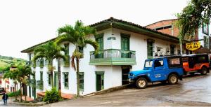 un camion bleu garé devant un bâtiment dans l'établissement Hotel Calima, à Restrepo