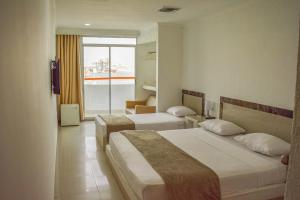 a hotel room with two beds and a window at Hotel Cartagena Premium in Cartagena de Indias