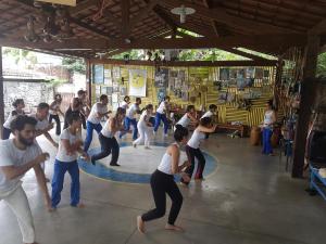 um grupo de pessoas dançando em um círculo em um ginásio em Albergue Cultural São Salomão no Recife