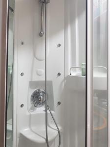 a shower with a hose in a white bathroom at ALBOR II in Gijón