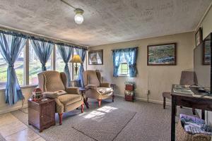 a living room with chairs and a table and windows at Quaint Getaway 2 Mi to Downtown and 3 Mi to UT! in Knoxville