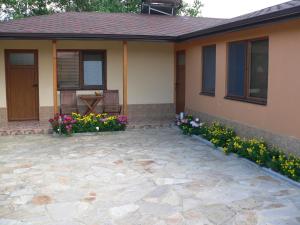 een huis met een patio en bloemen ervoor bij Лорета-Камен бряг in Kamen Bryag