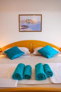 ein Bett mit blauen Kissen und blauen Handtüchern darauf in der Unterkunft Summer Vibes in Sveti Petar