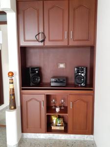 un armario de madera con 2 microondas y 2 cámaras en Hotel Mirador Santana, en Anserma