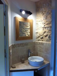 baño con lavabo y pared de piedra en Malia - Chambres d'hôtes & Gîte, en Barret-de-Lioure