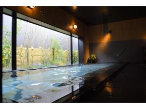 ein großer Pool mit großem Fenster in der Unterkunft Hotel Route-Inn Shinfujieki Minami in Fuji