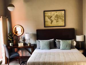 Hotel Real de Piedra في Pénjamo: غرفة نوم مع سرير مع خريطة على الحائط