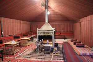 a large room with a fireplace and tables and chairs at Mohammed Mutlak Camp in Wadi Rum +31 photos