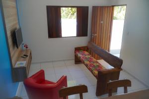 een woonkamer met een bank en een stoel bij Flat Vila dos Milagres in São Miguel dos Milagres
