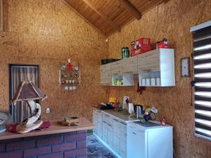 cocina con armarios azules y nevera blanca en Forest Lodge on the Pyramid en Visoko