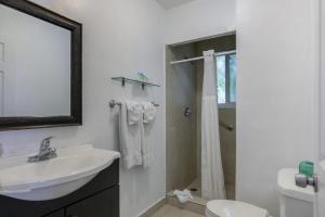 a white bathroom with a sink and a shower at Hollywood Broadwalk Oceanside Hotel in Hollywood