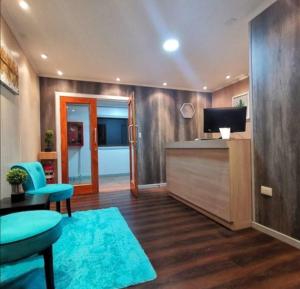 a living room with a tv and a desk with a television at Hotel Mont Suite-Mte. Aguila in Cabrero