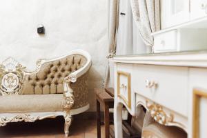 una sedia in oro e bianco in una stanza con specchio di Na-anché Hotel a Città di Oaxaca