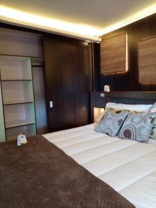 - une chambre avec un grand lit et une tête de lit en bois dans l'établissement Hotel Mont Suite-Mte. Aguila, à Cabrero